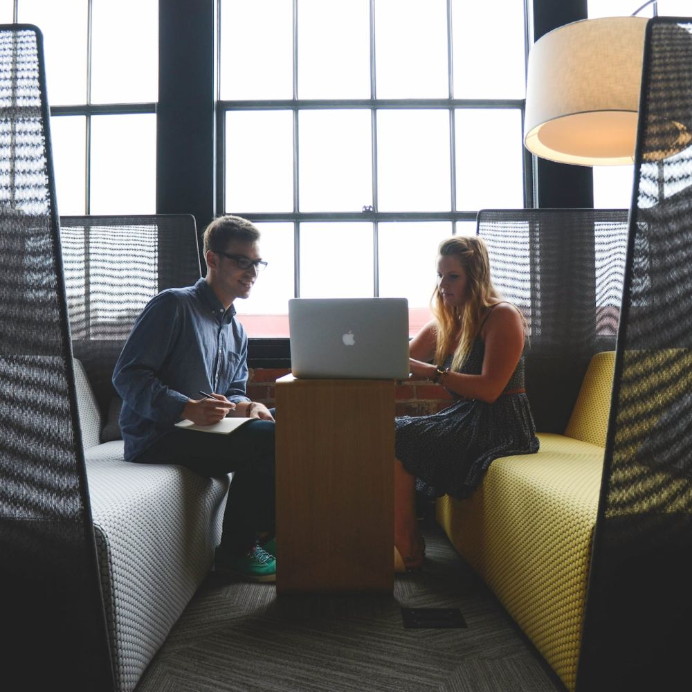 Zwei Unternehmer sitzen in einem Workspace und arbeiten zusammen